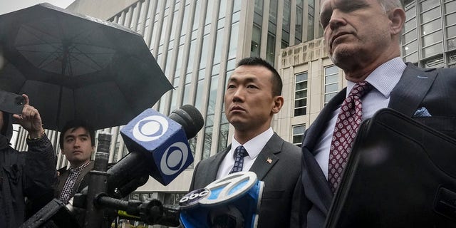 NYPD Officer Baimadajie Angwang, left, and his attorney, John Carman, hold a press briefing after a judge dismissed spy charges against him on Thursday, Jan. 19, 2023, in New York.