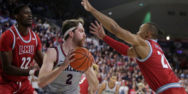 Loyola Marymount center Rick Issanza, left, and guard Cam Shelton double-team Gonzaga forward Drew Timme, Thursday, Jan. 19, 2023, in Spokane.