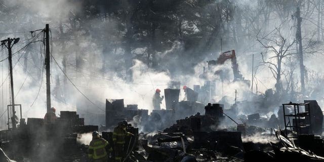 Firefighters clean up the site of a fire at Guryong village in Seoul, South Korea, Friday, Jan. 20, 2023. A fire spread through a neighborhood of densely packed, makeshift homes in South Korea's capital Friday morning. 