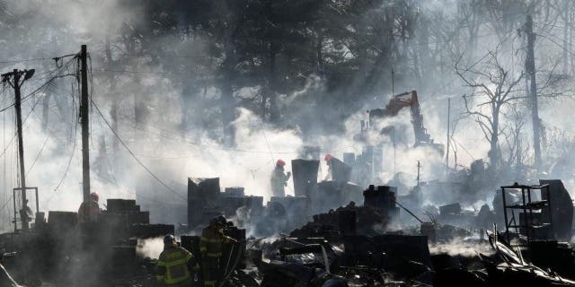 Firefighters clean up the site of a fire at Guryong village in Seoul, South Korea, Friday, Jan. 20, 2023. A fire spread through a neighborhood of densely packed, makeshift homes in South Korea's capital Friday morning.
