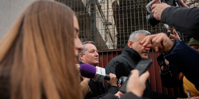 Consul-generaal van de Amerikaanse ambassade in Roemenië, John Gimbel, middenlinks, verlaat een detentiecentrum van de politie in het centrum van Boekarest, Roemenië, vrijdag 20 januari 2023.