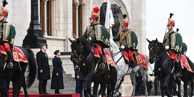 Hungarian President Katalin Novak, right, receives Croatian President Zoran Milanovic, left, with military honours at the parliament building in Budapest, Hungary, Friday, Jan. 20, 2023.
