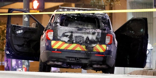 A burned police car sits on the street following a violent protest, Jan. 21, 2023, in Atlanta, in the wake of the death of an environmental activist killed after authorities said the 26-year-old shot a state trooper.