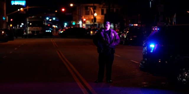 A police officer stands near a scene where a shooting took place in Monterey Park, Calif., Sunday, Jan. 22, 2023. Dozens of police officers responded to reports of a shooting that occurred after a large Lunar New Year celebration had ended in a community east of Los Angeles late Saturday. 