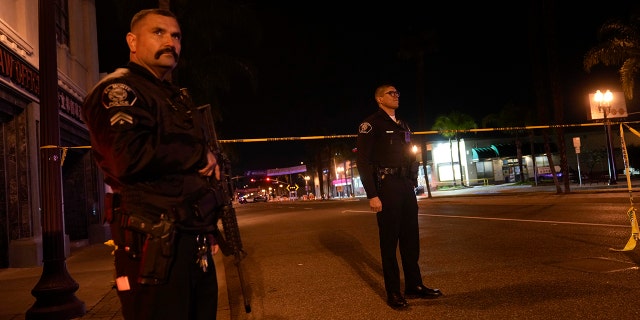 Two police officers stand guard near a scene where a shooting took place in Monterey Park, Calif., Sunday, Jan. 22, 2023. 