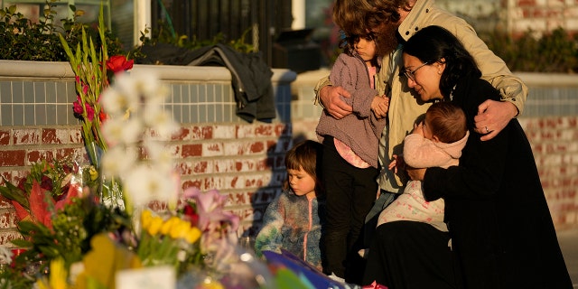 A family gathers at a memorial outside the Star Ballroom Dance Studio on Tuesday, Jan. 24, 2023, in Monterey Park, Calif. A gunman killed multiple people at the ballroom dance studio late Saturday amid Lunar New Years celebrations in the predominantly Asian American community. 