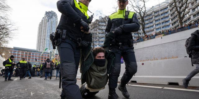 Police detained a protestor after Extinction Rebellion activists and sympathisers blocked a busy road in The Hague, Netherlands, Saturday, Jan. 28, 2023. Earlier this week seven Extinction Rebellion activists were detained by authorities for sedition linked to the protest.