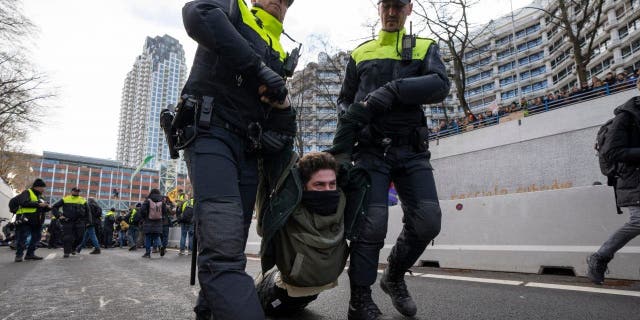 Police detained a protestor after Extinction Rebellion activists and sympathisers blocked a busy road in The Hague, Netherlands, Saturday, Jan. 28, 2023. Earlier this week seven Extinction Rebellion activists were detained by authorities for sedition linked to the protest. 