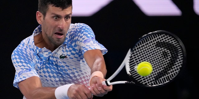 Novak Djokovic of Serbia plays a backhand return to Stefanos Tsitsipas of Greece during the men's singles final at the Australian Open tennis championships in Melbourne, Australia, Sunday, January 29, 2023. 