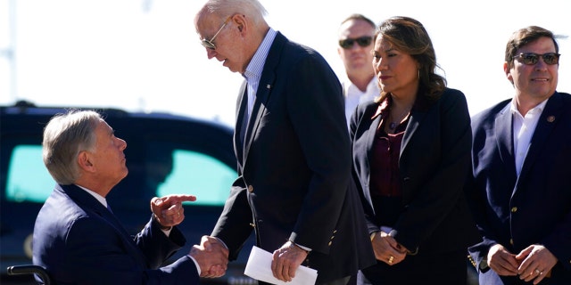 President Joe Biden, right, shakes hands with Texas Gov.  Greg Abbott after Abbott handed him a letter about the border at El Paso International Airport in El Paso, Texas, Sunday, Jan. 8, 2023.