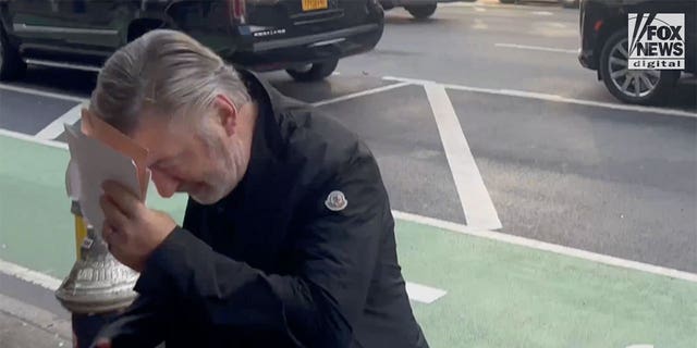 Alec Baldwin holds up an envelope to his face as he enters a building in New York City on Jan. 20, 2023. It was the first time Baldwin was seen after being charged with involuntary manslaughter in the fatal shooting of cinematographer Halyna Hutchins on the set of "Rust" in 2021.