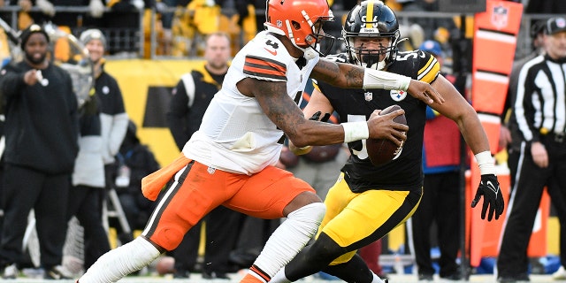 Cleveland Browns oyun kurucusu Deshaun Watson, 8 Ocak 2023 Pazar günü Pittsburgh'daki bir NFL futbol maçının ikinci yarısında savunma yapan Pittsburgh Steelers defans oyuncusu Alex Highsmith ile cebini karıştırıyor.