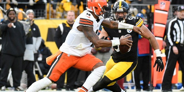 El mariscal de campo de los Cleveland Browns, Deshaun Watson, patea desde el bolsillo con el linebacker de los Pittsburgh Steelers, Alex Highsmith, a la defensiva durante la segunda mitad de un partido de fútbol americano de la NFL en Pittsburgh, el domingo 8 de enero de 2023.