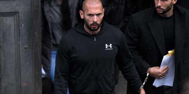 Andrew Tate, center, leaves after appearing at the Court of Appeal, in Bucharest, Romania, on Jan. 10, 2023. Tate arrived at a court in Romania in handcuffs to appeal a judge's earlier decision to extend his arrest period from 24 hours to 30 days on multiple different charges including rape and human trafficking.