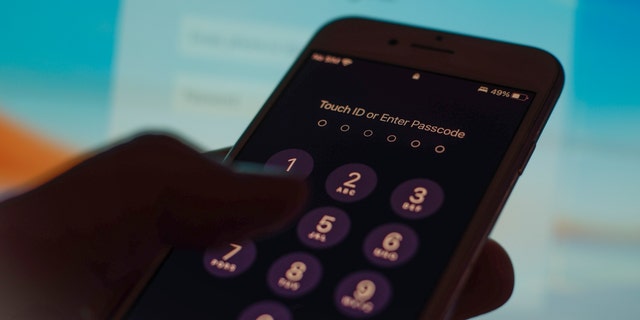 A mobile phone passcode security screen is seen in this photo illustration