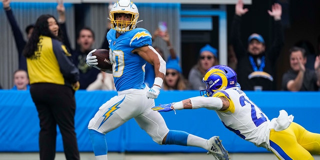 Los Angeles Chargers running back Austin Ekeler (30) evades a tackle by Los Angeles Rams safety Taylor Rapp as he runs into the end zone for a score during the first half of a Los Angeles Rams football game. the NFL on Sunday, January 1, 2023, in Inglewood, California. 