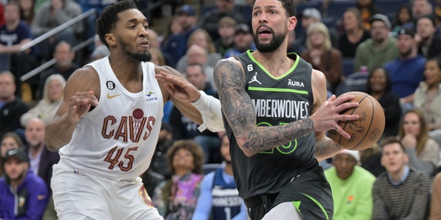 El portero de los Minnesota Timberwolves, Austin Rivers, se dirige a la canasta mientras el portero de los Cleveland Cavaliers, Donovan Mitchell, defiende en Target Center en Minneapolis el 14 de enero de 2023.