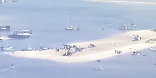 This image made from a video shows sand bank with crashed helicopter on Gold Coast, Australia Monday, Jan. 2, 2023. Two helicopters collided Monday afternoon over the Australian beach.