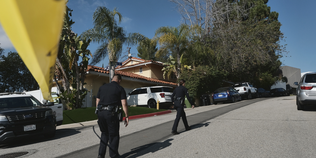 Police block the street to a house where three people were killed and four others wounded in a shooing at a short-term rental home in an upscale Los Angeles neighborhood on Saturday, Jan. 28.