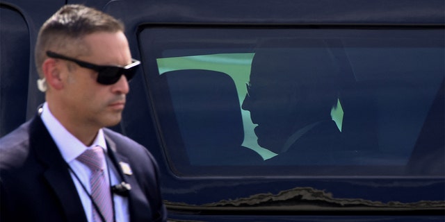A Secret Service agent stands guard as President Biden sits inside the presidential SUV after arriving at Delaware National Guard Air Base in New Castle, Delaware, on June 18, 2021.