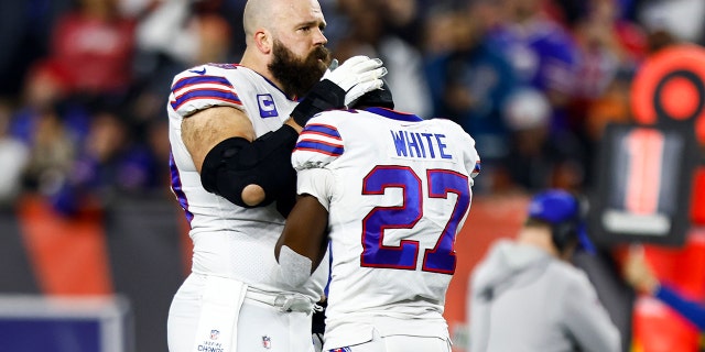 Mitch Morse #60 of the Buffalo Bills consoles Tre'Davious White #27 after Damar Hamlin #3 suffered an injury during the first quarter of an NFL football game against the Cincinnati Bengals at Paycor Stadium on January 2. January 2023 in Cincinnati, Ohio.