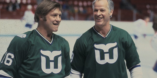 Gordie Howe #9 and Bobby Hull #16 of the Hartford Whalers look on against the Montreal Canadiens in the 1980s at the Montreal Forum in Montreal, Quebec, Canada.