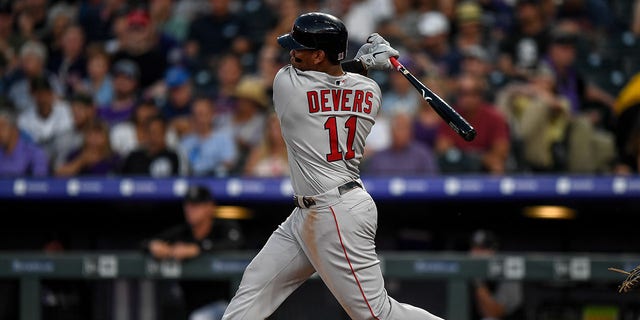 Boston Red Sox third baseman Rafael Devers (11) hits a triple against the Colorado Rockies during a game Aug. 28, 2019, at Coors Field in Denver, Colo. 