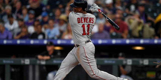 Boston Red Sox third baseman Rafael Devers (11) hits a triple against the Colorado Rockies during a game Aug. 28, 2019, at Coors Field in Denver, Colo.