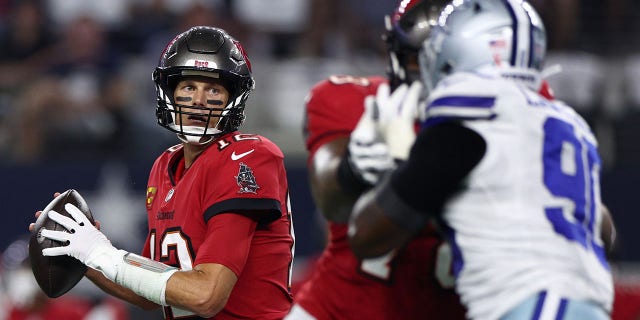 Tom Brady #12 of the Tampa Bay Buccaneers look to throw against the Dallas Cowboys during the first half at AT&T Stadium on September 11, 2022 in Arlington, Texas.