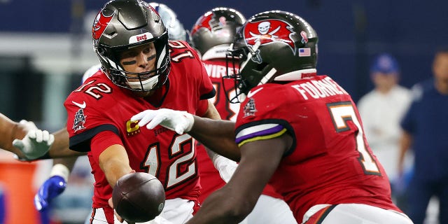 Tom Brady (12) hands off to Leonard Fournette (7) of the Tampa Bay Buccaneers during a game against the Dallas Cowboys at AT and T Stadium Sept. 11, 2022, in Arlington, Texas.