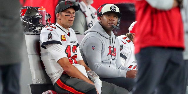 Le quart-arrière des Buccaneers de Tampa Bay, Tom Brady (12 ans), est assis avec le coordinateur offensif Byron Leftwich lors d'un match de joker NFC contre les Cowboys de Dallas le 16 janvier 2023, au stade Raymond James de Tampa, en Florida.