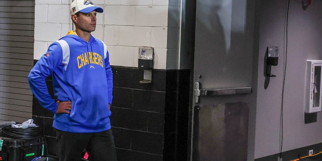 El entrenador en jefe Brandon Staley se encuentra en un silencio atónito fuera del vestuario, esperando que sus jugadores abandonen el campo después de perder 31-30 ante los Jacksonville Jaguars en un juego de comodines de la AFC en el TIAA Bank Field. 