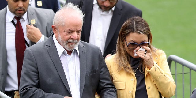 El presidente brasileño, Luiz Inácio Lula da Silva, y su esposa, Rosangela da Silva, como el cuerpo de la leyenda del fútbol brasileño Pelé, yacen en el campo del estadio Vila Belmiro de su antiguo club, el Santos.