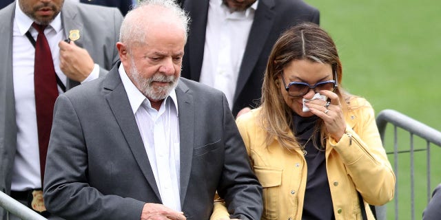 El presidente brasileño, Luiz Inácio Lula da Silva, y su esposa, Rosangela da Silva, como el cuerpo de la leyenda del fútbol brasileño Pelé, yacen en el campo del estadio Vila Belmiro de su antiguo club, el Santos.