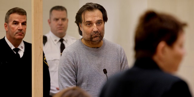 Brian Walshe, center, listens during his arraignment Wednesday, Jan. 18, 2023, at Quincy District Court, in Quincy, Mass., on a charge of murdering his wife Ana Walshe. 