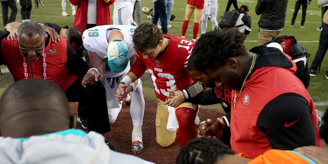 Il quarterback dei San Francisco 49ers Brock Purdy si unisce ad altri giocatori in preghiera dopo la partita contro i Miami Dolphins al Levi's Stadium di Santa Clara, in California, il 4 dicembre 2022.