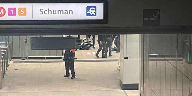 Police surround a man who sits on the floor of a metro station near EU headquarters in Brussels, on Jan. 30, 2023. News reports said that one man was injured in a knife incident around the European Union's headquarters in Brussels before one suspect was detained. The knife attack is not considered to be terrorism.