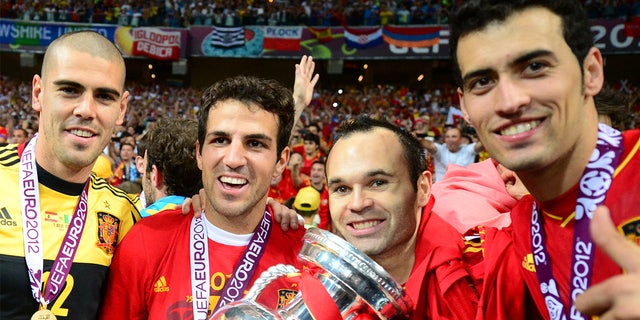 Spanish goalkeeper Victor Valdes, Spanish midfielder Cesc Fabregas, Spanish midfielder Andres Iniesta and Spanish midfielder Sergio Busquets pose with the trophy after winning the Euro 2012 final match between Spain and Italy on July 1, 2012 at the Estadio kyiv Olympic.
