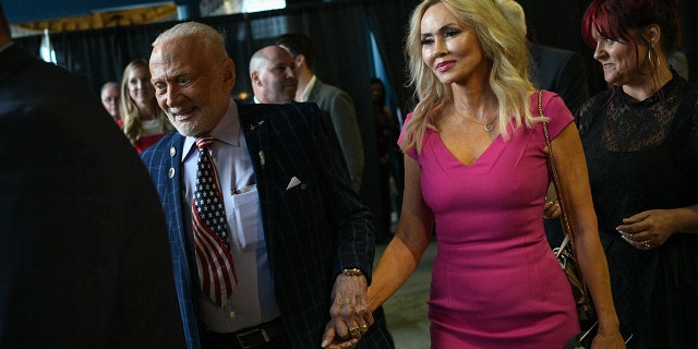 Former NASA astronaut Buzz Aldrin makes his entrance with girlfriend Anca Faur at an Apollo 11 anniversary celebration dinner at the Davidson Center for Space Exploration July 17, 2019, at the U.S. Space and Rocket Center in Huntsville, Alabama. 