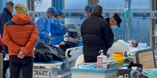 Medical workers check on an elderly patient as he arrives to an emergency hall in a hospital in Beijing, Saturday, Jan. 7, 2023.