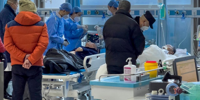 Medical workers check on an elderly patient as he arrives to an emergency hall in a hospital in Beijing Saturday, Jan. 7, 2023.