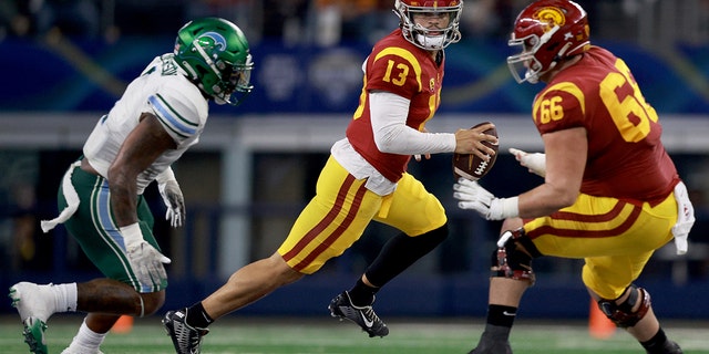 Caleb Williams #13 of the USC Trojans fights against the Tulane Green Wave in the second quarter of the Goodyear Cotton Bowl Classic on January 2, 2023 at AT&T Stadium in Arlington, Texas.