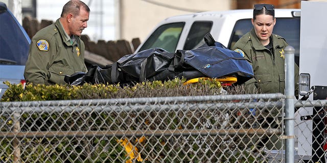 Tulare County Sheriff crime unit removes the body of one of the victims at the scene where six people were killed in Goshen, California, on Jan. 16.