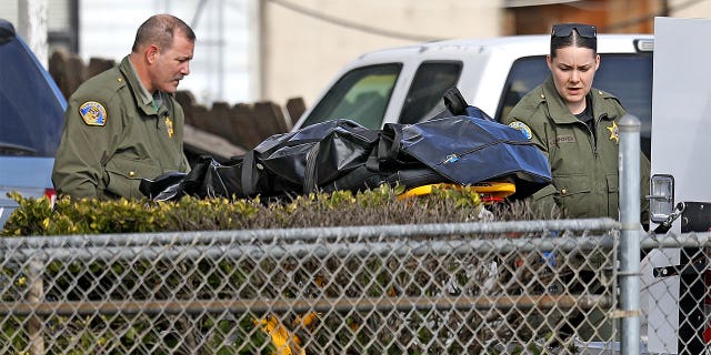 Tulare County Sheriff crime unit removes the body of one of the victims at the scene where six people were killed in Goshen, California, on Jan. 16.