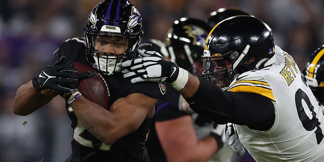 J.K. Dobbins of the Ravens breaks a tackle from Cameron Heyward of the Pittsburgh Steelers on Jan. 1, 2023, in Baltimore, Maryland.