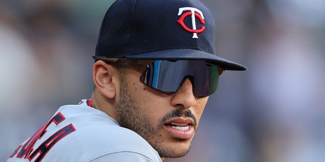 Carlos Correa looks on