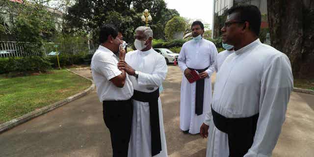 A Catholic priest stands with a family member of one of the deceased after Sri Lanka’s Supreme Court pronounced judgment on the 2019 Easter Sunday bomb attacks in Colombo, Sri Lanka, on Jan. 12, 2023. Sri Lanka’s Supreme Court ruled that inaction by the country's former president and other officials led to the attacks that killed nearly 270 people.