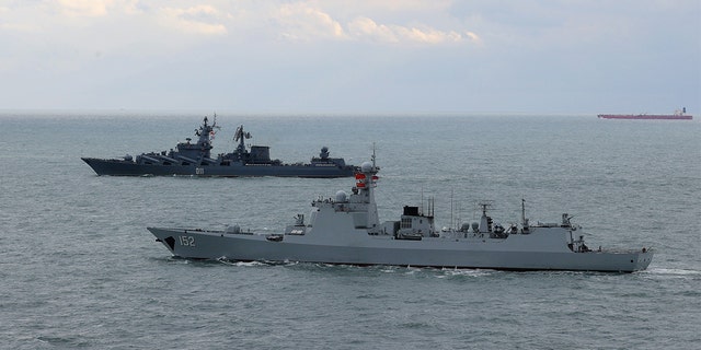 FILE: Destroyer Jinan from Chinese navy front and cruiser Varyag from Russian navy sail in formation after a joint naval exercise, Joint Sea 2022, in the East China Sea on December 27, 2022.