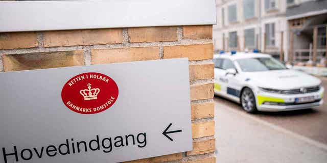 A police car is shown in front of the court in Holbaek, Denmark. A 16-year-old was charged with joining a white supremacist, neo-Nazi group and trying to recruit others to join him. His trial is set to start on March 12, 2023, at the court in Holbaek.