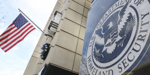 homeland security logo on building, US flag at left